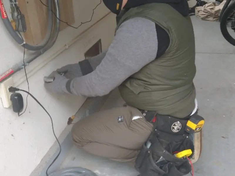 Electrician performing outlet wiring in a Flint garage